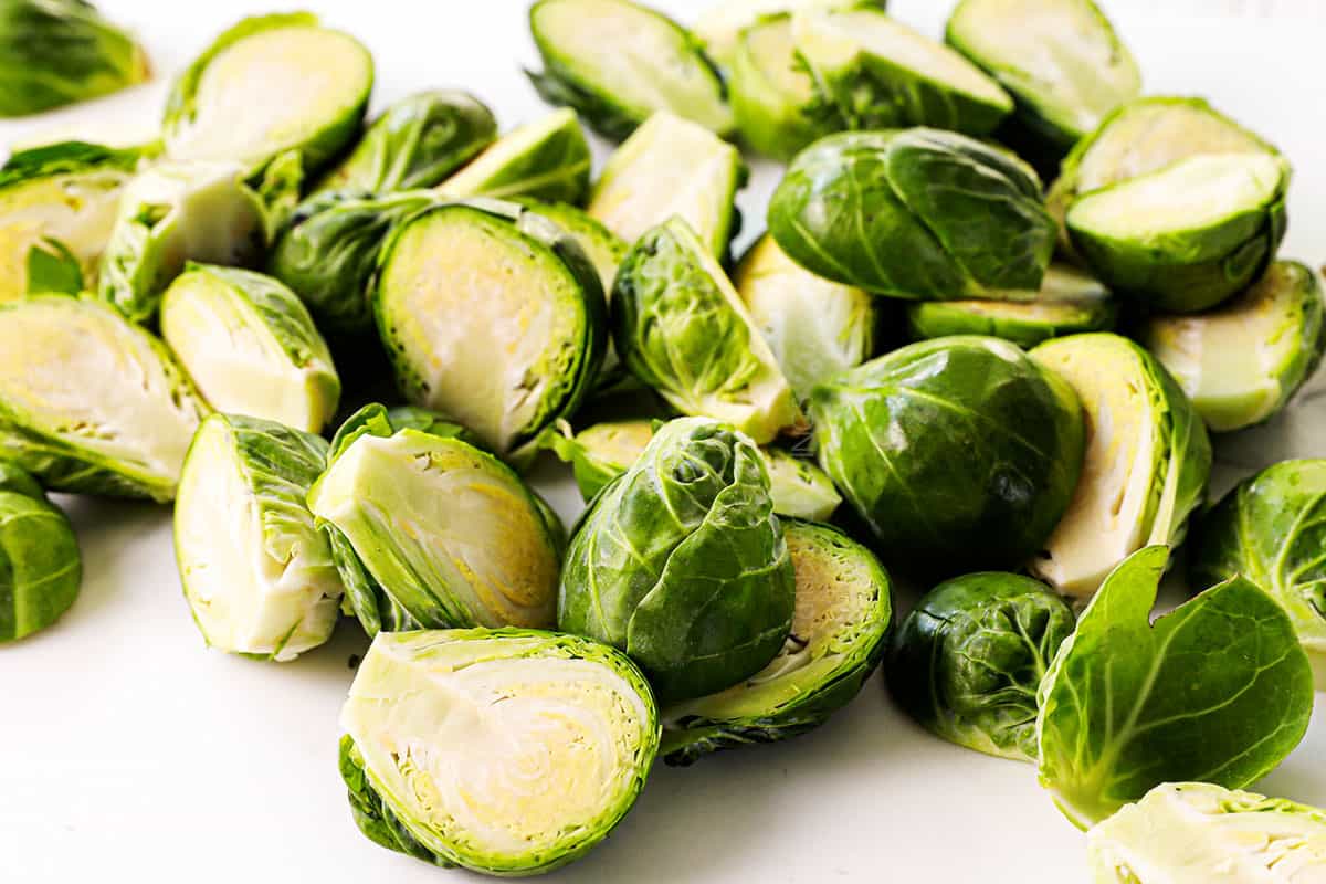 showing how to make Bacon Wrapped Brussels Sprouts by slicing the sprouts in half lengthwise