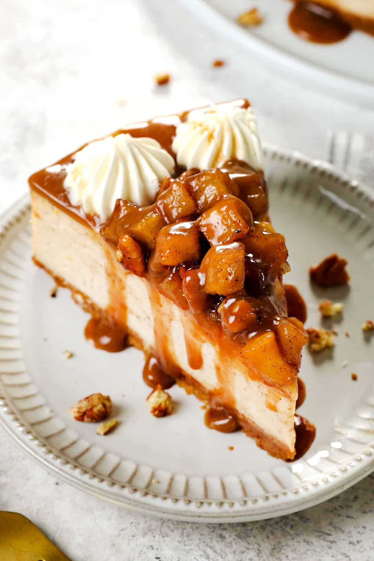 a slice of caramel apple cheesecake with apples piled on top