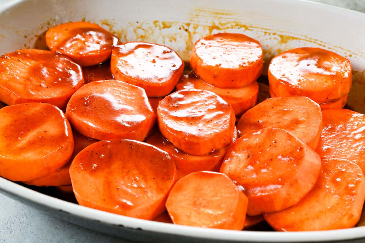 showing how to make candied yams (candied sweet potatoes) by pouring the syrup over the sliced potatoes in a baking dish