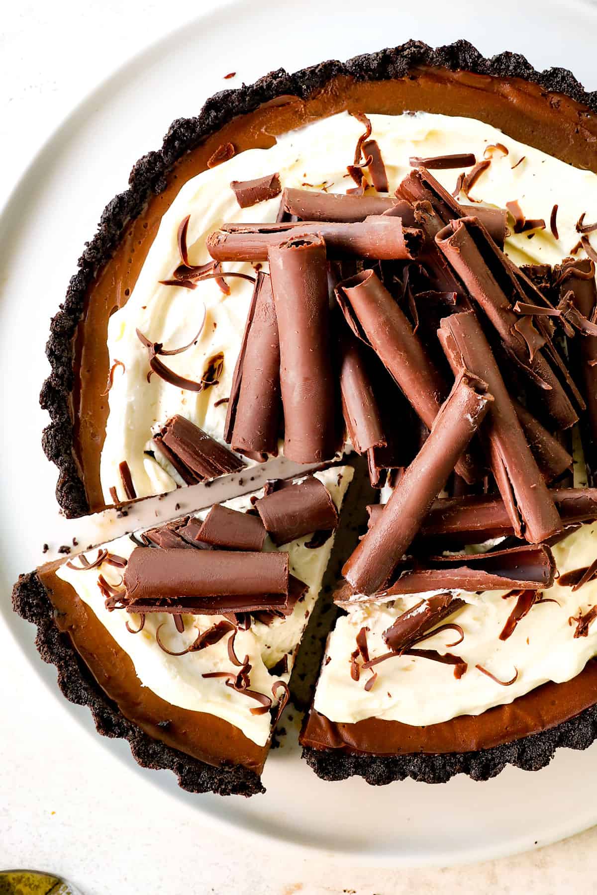 top view of chocolate cream pie with a piece being served