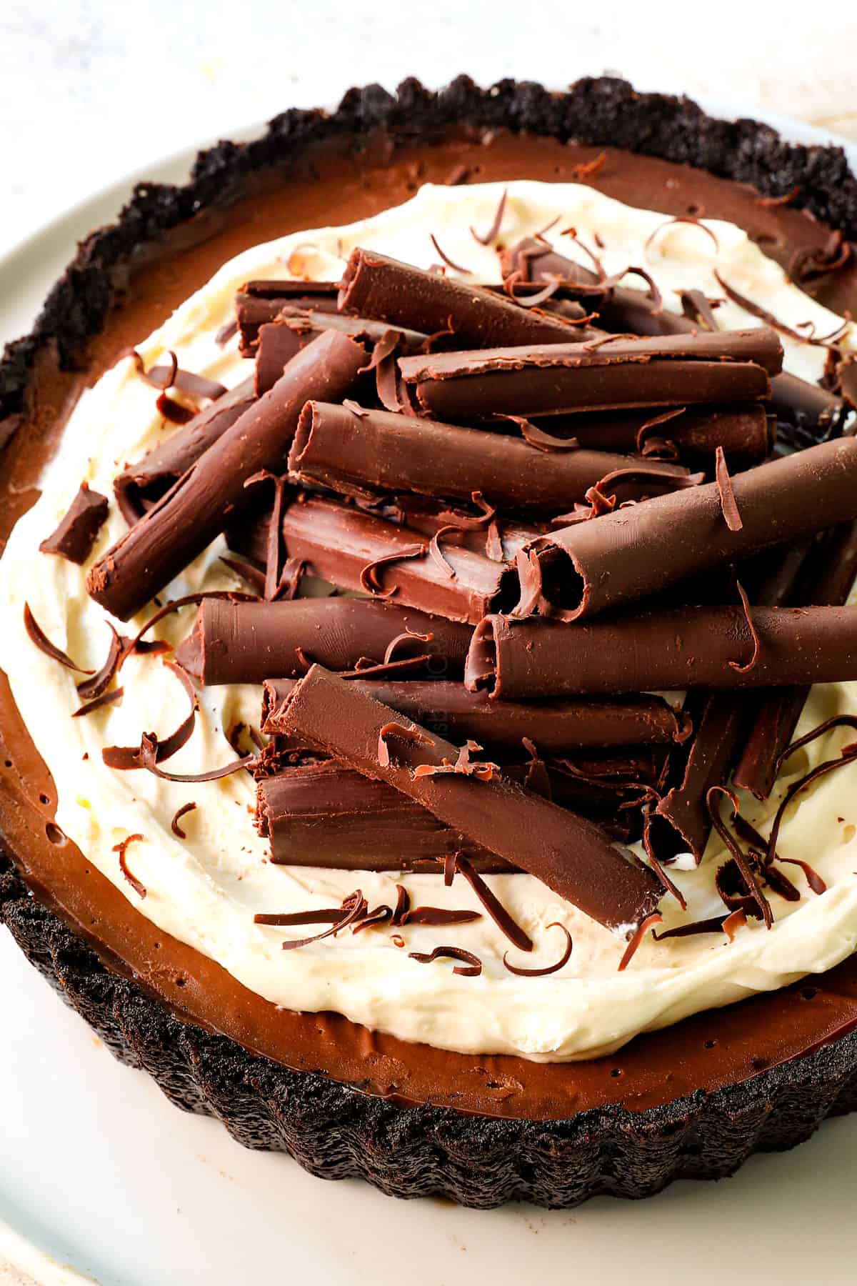 classic chocolate cream pie with whipped cream topping and chocolate shavings and an Oreo crust