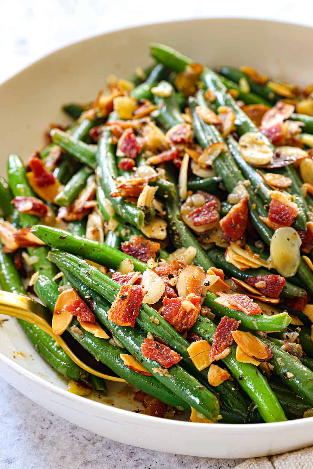 easy green bean almondine recipe with garlic being served in a white dish