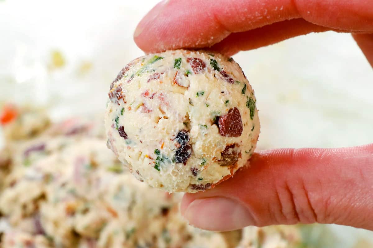 showing how to make mini cheese balls by rolling into balls using a cookie scoop