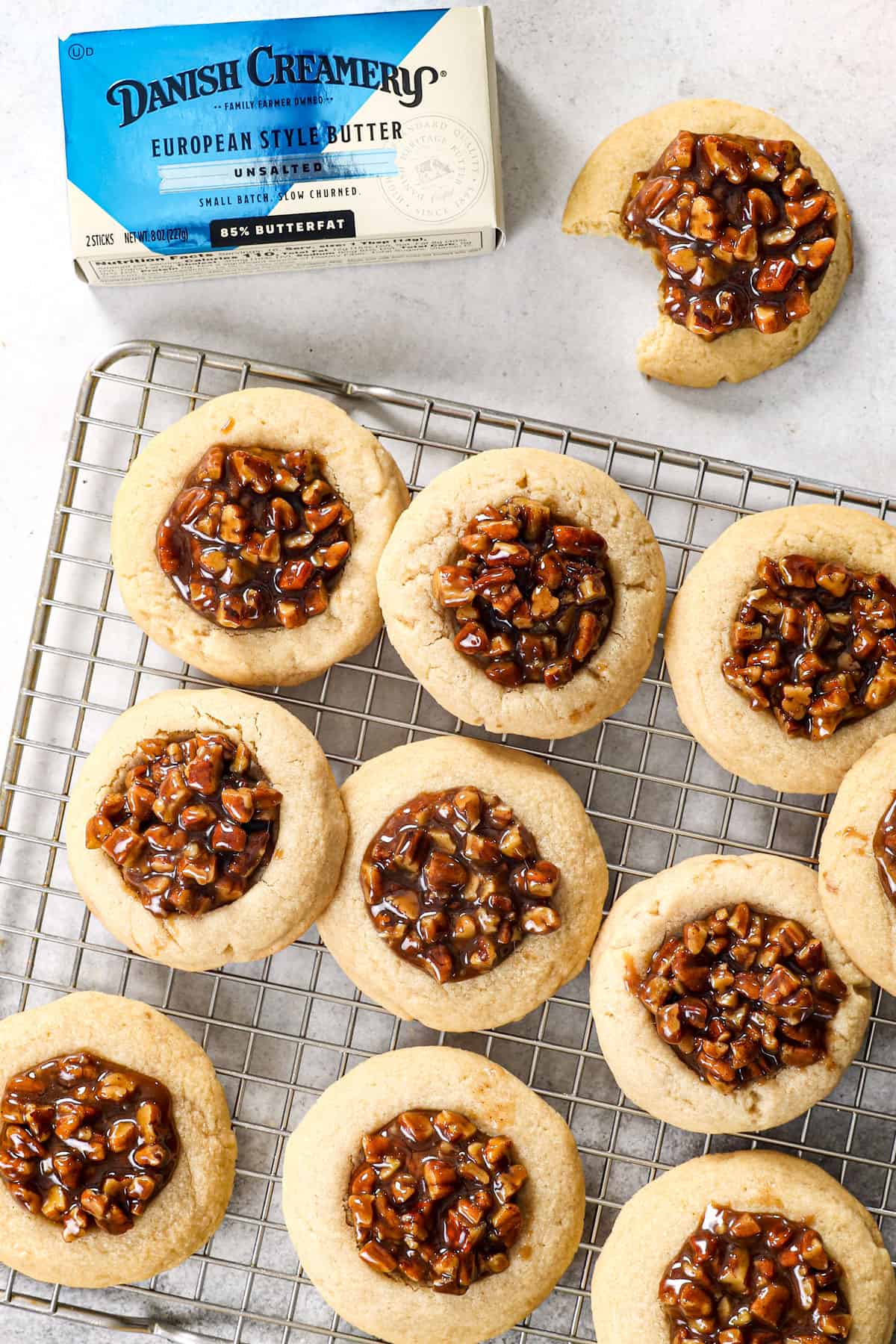 pecan pie cookies with thumbprints on a baking sheet with pecan pie filling