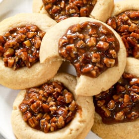 serving pecan pie thumbprint cookies on a white platter