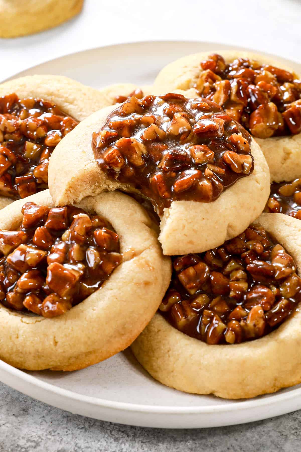 pecan pie thumbprint cookies stacked on a plate