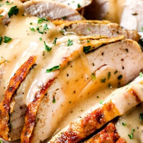 up close of roasted turkey breast with gravy showing how juicy it is