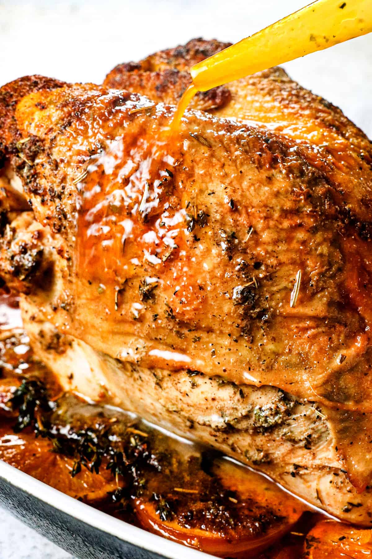 showing how to make roast turkey breast by basting the turkey breast with juices from the pan
