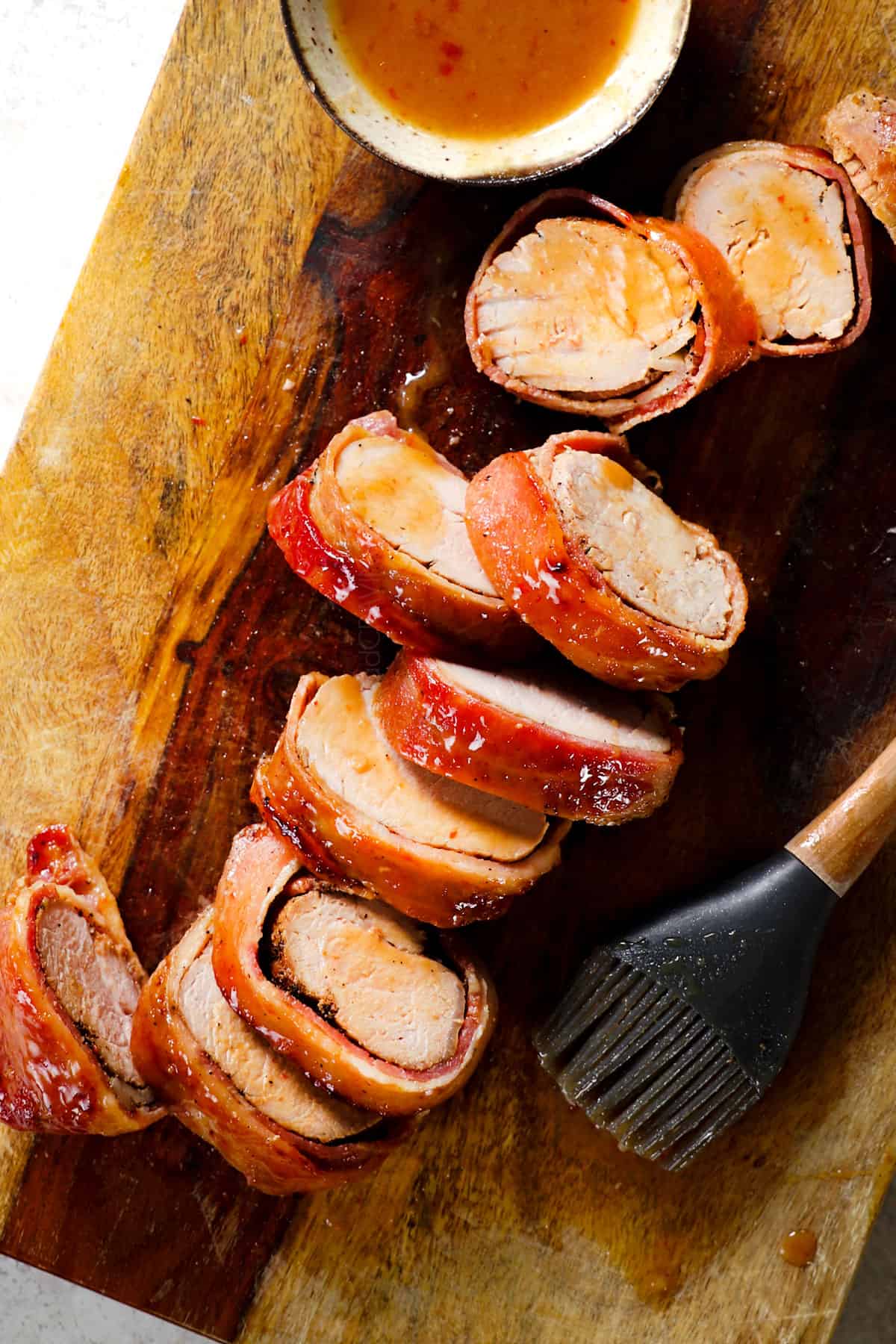 top view of bacon-wrapped pork tenderloin on a cutting board