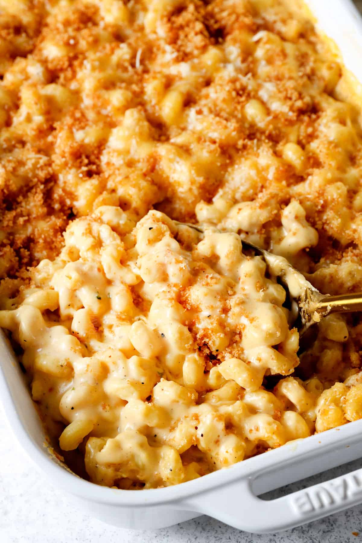 scooping up baked macaroni and cheese with breadcrumbs made with cheddar, Gruyere and Gouda