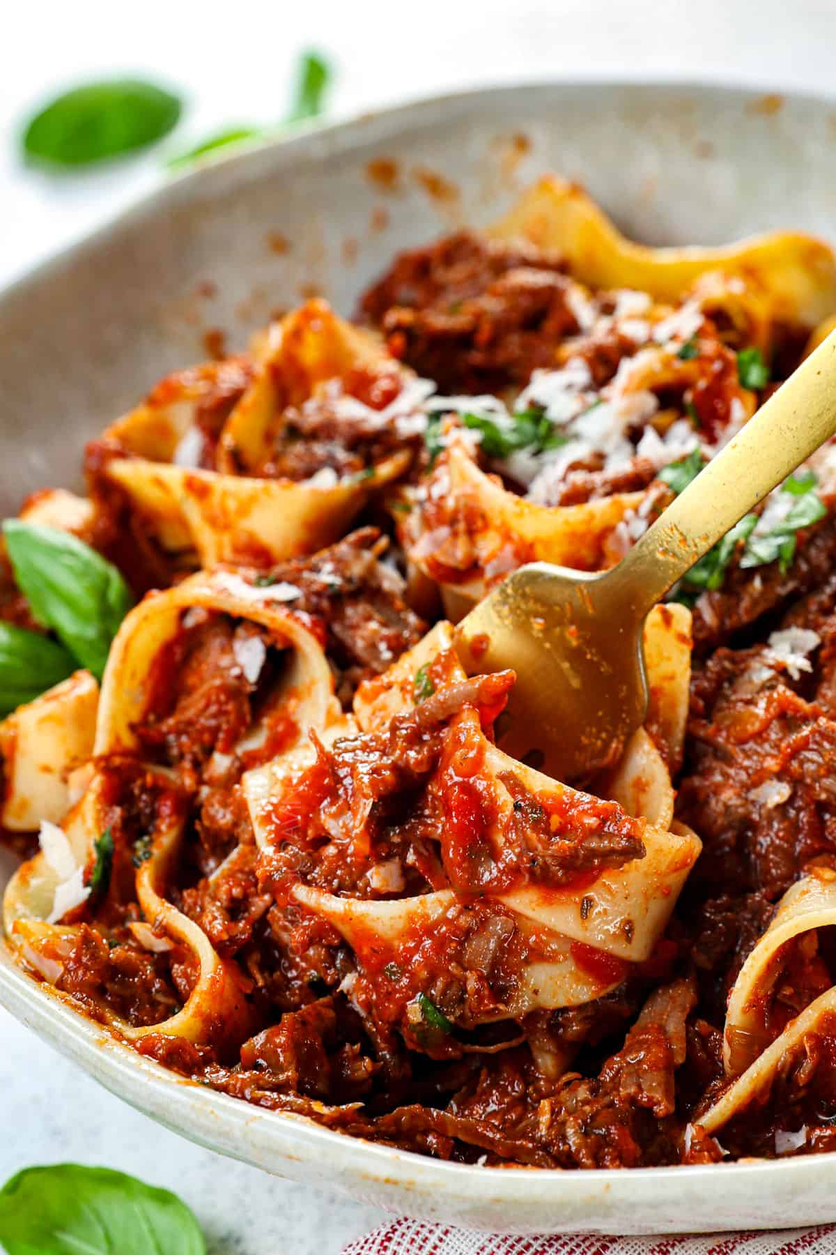 up close of twirling beef ragu with pappardelle on fork