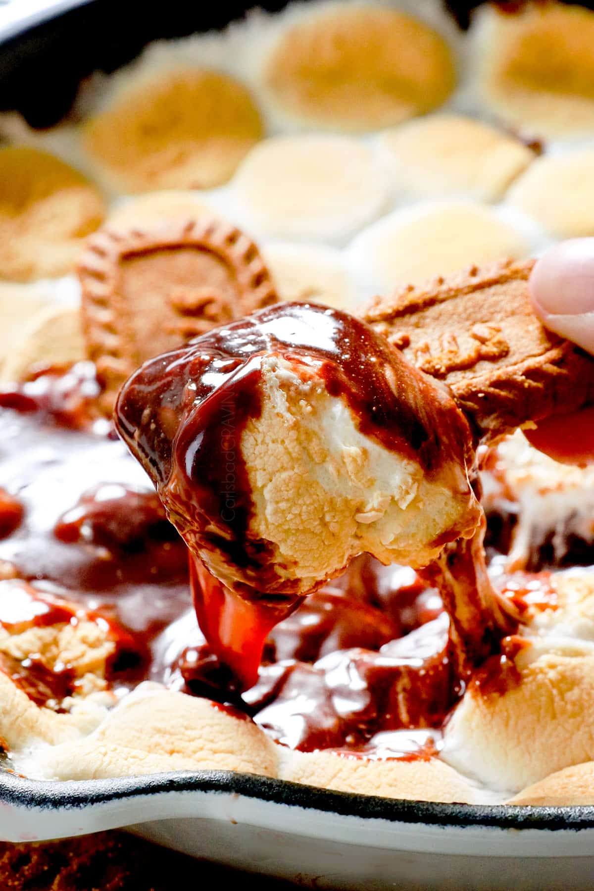 dipping cookie into chocolaty s'mores dip