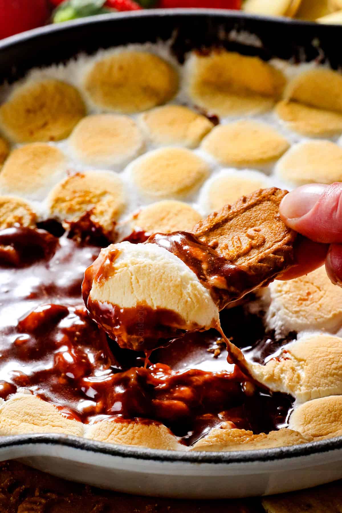 dipping cookie into chocolaty s'mores dip