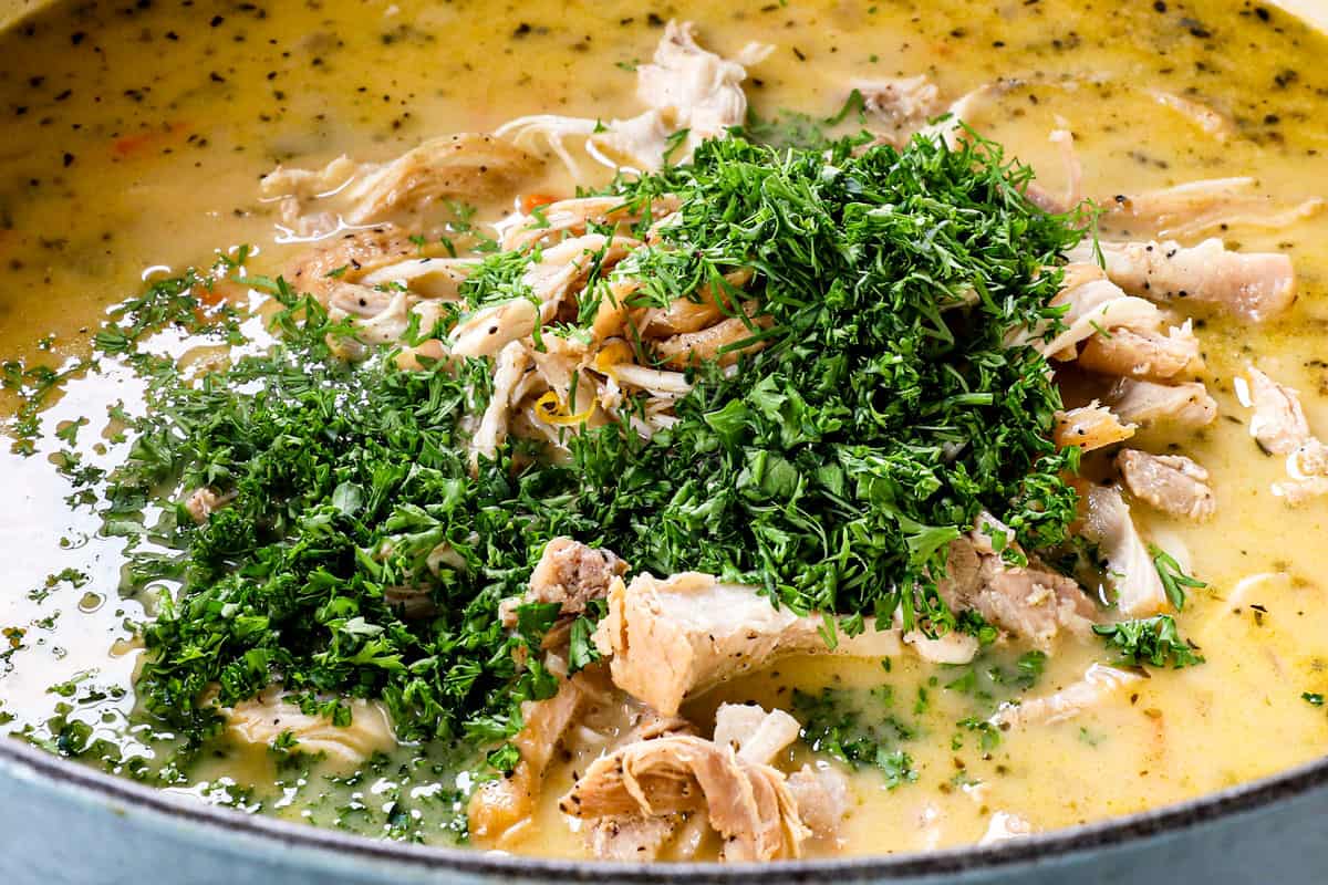 showing how to make traditional Avgolemono Soup recipe (Greek Lemon Chicken Soup) by adding shredded chicken, fresh dill and fresh parsley to the soup
