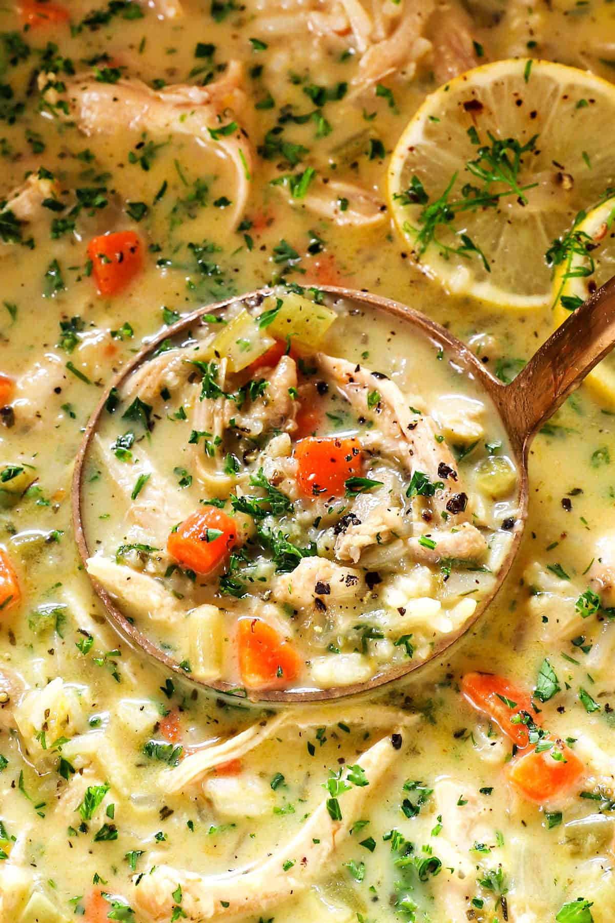 up close of a ladle of Avgolemono Soup (Greek Lemon Chicken Soup) showing how creamy it is