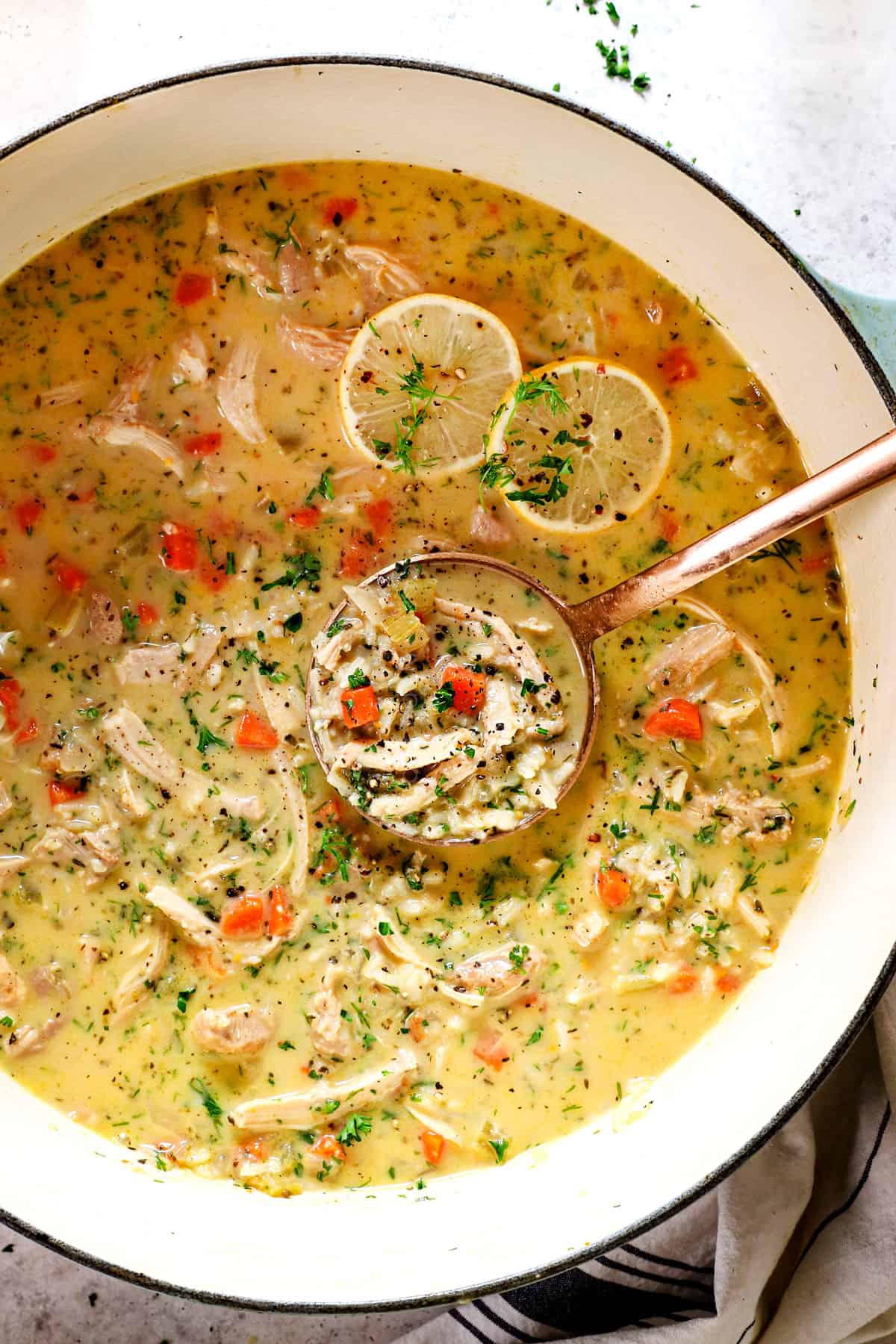 showing how to make make Avgolemono Soup (Greek Lemon Chicken Soup) by adding fresh parsley and dill