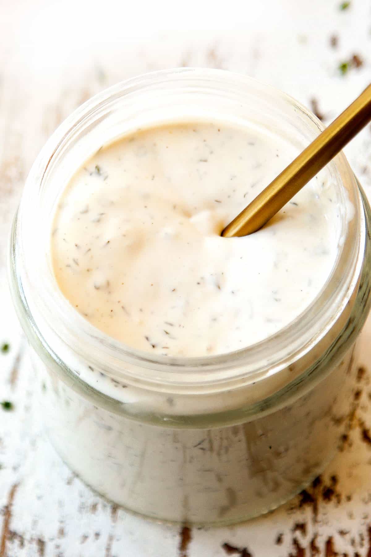 stirring the best blue cheese dressing in a jar