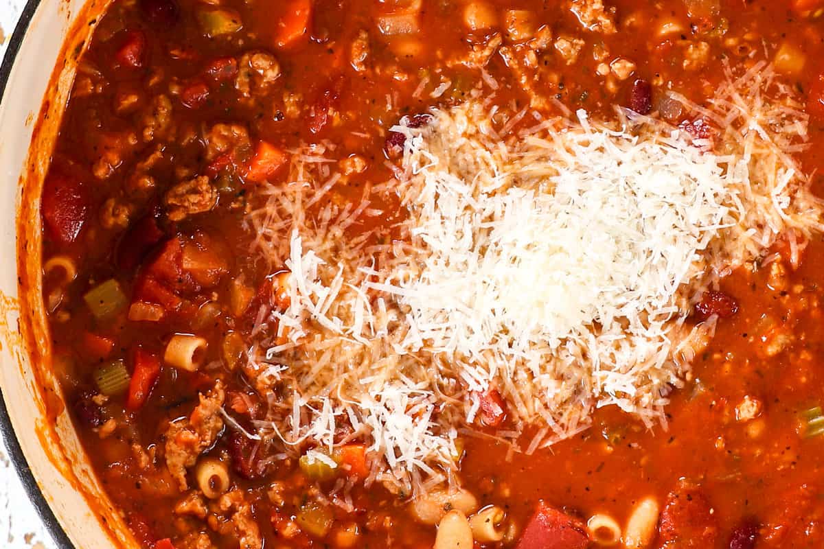 showing how to make pasta e fagioli soup (pasta fazool) by stirring in Parmesan cheese