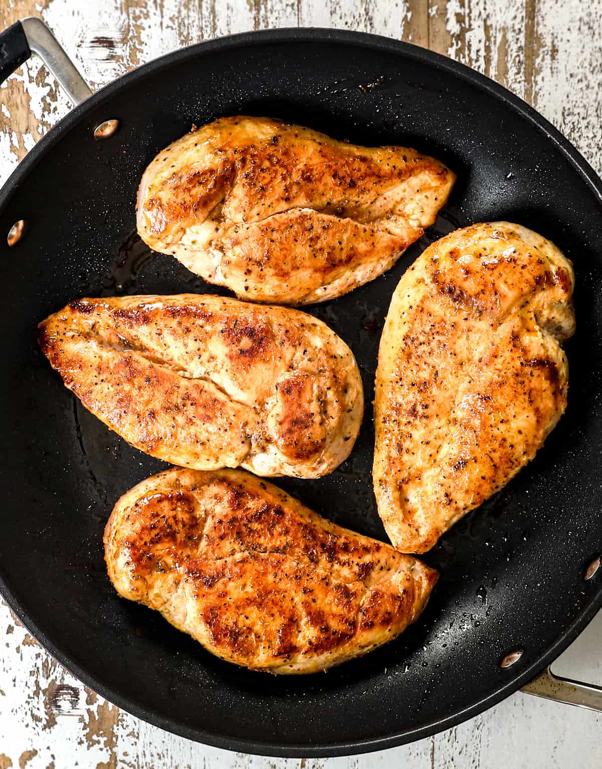 showing how to make shredded chicken by searing the chicken breasts in a nonstick skillet
