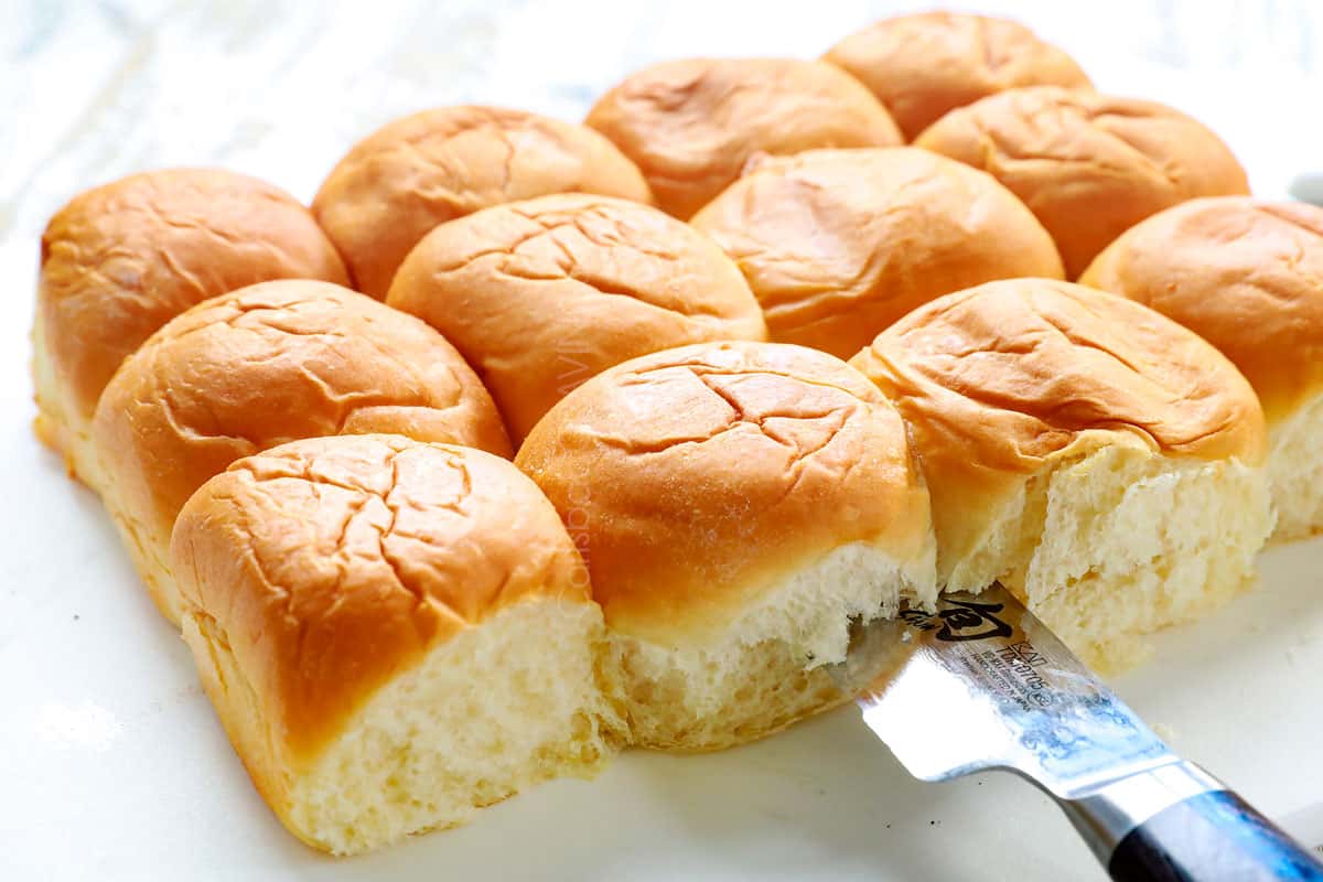 showing how to make Hawaiian ham and cheese sliders by slicing the Hawaiian rolls in half to create two slabs of rolls