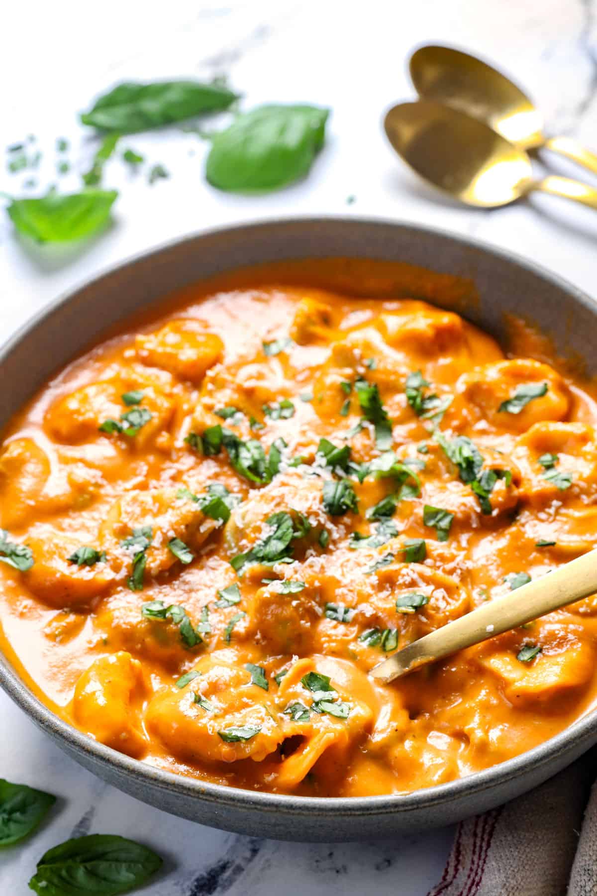 a spoon scooping up tomato tortellini soup showing how creamy it is