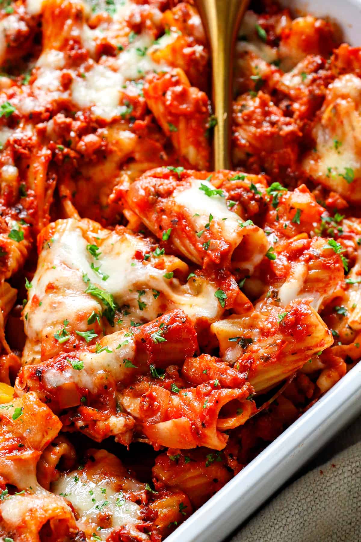 up close of a scoop of baked rigatoni with sausage showing how cheesy it is