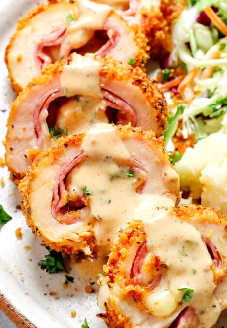 serving baked chicken cordon bleu on a plate with mashed potatoes