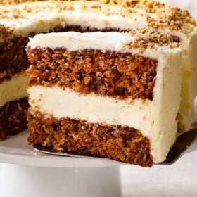 serving a slice of carrot cake cheesecake recipe with cream cheese frosting