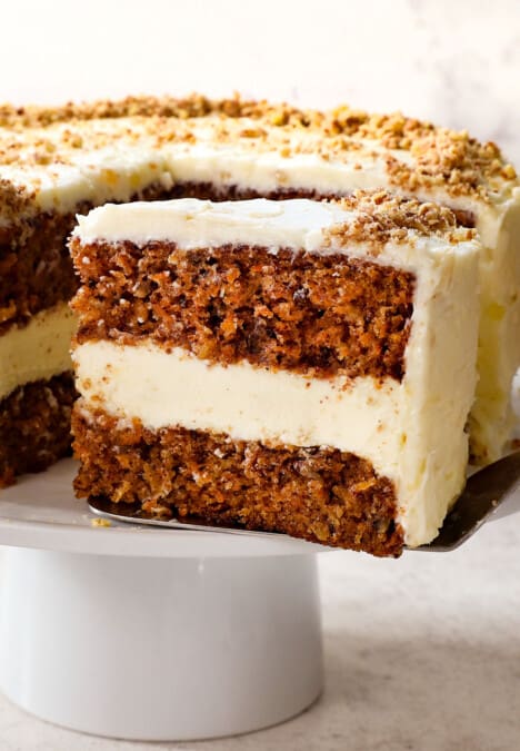 serving a slice of carrot cake cheesecake recipe with cream cheese frosting