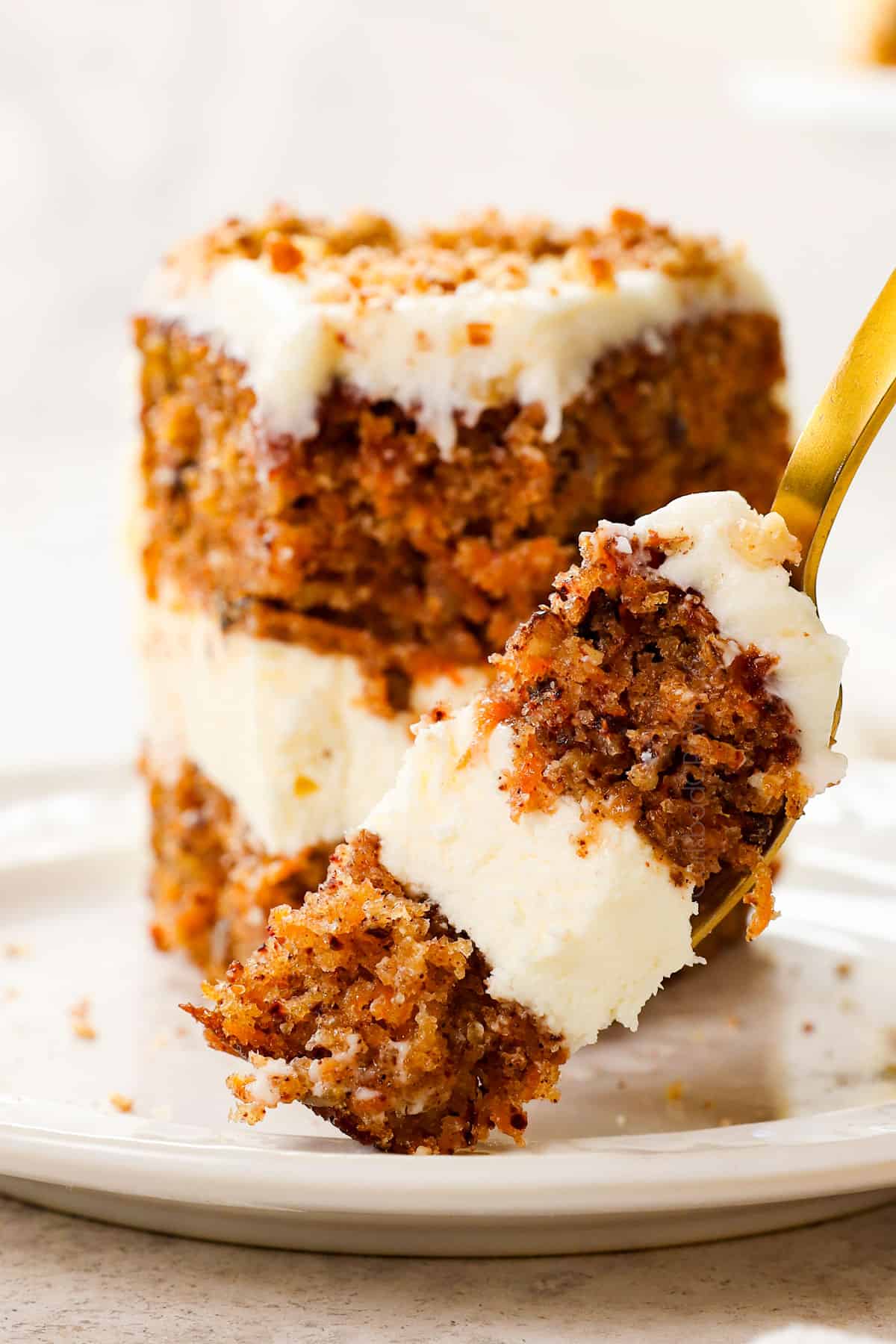 up close of taking a bite of carrot cake cheesecake with cream cheese frosting