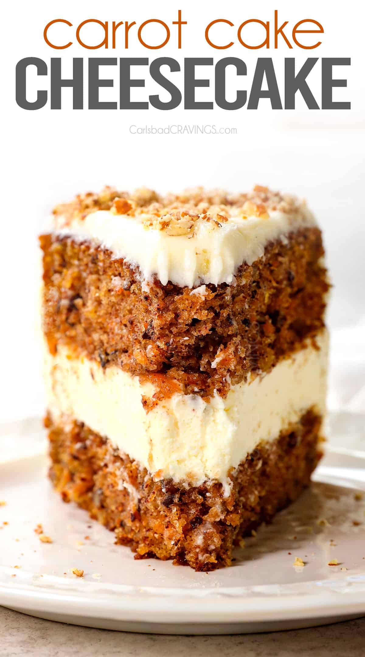 up close of a slice of carrot cake cheesecake with carrot cake on the top and bottom layers and cheesecake in the middle covered in cream cheese frosting