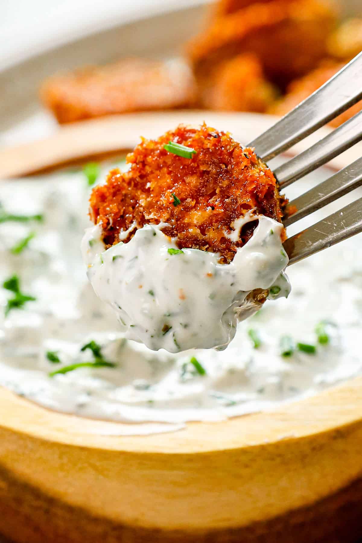 up closer of serving crispy Parmesan crusted potatoes by dipping in creamy herb sauce