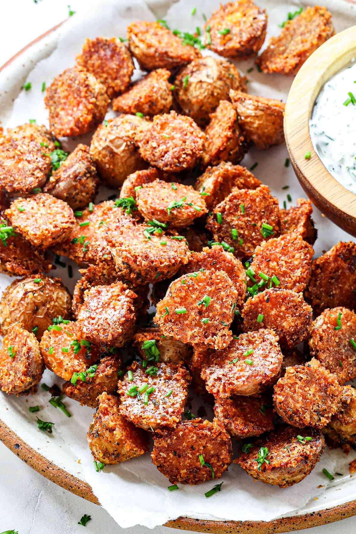 Parmesan crusted potatoes being served with herb dip 