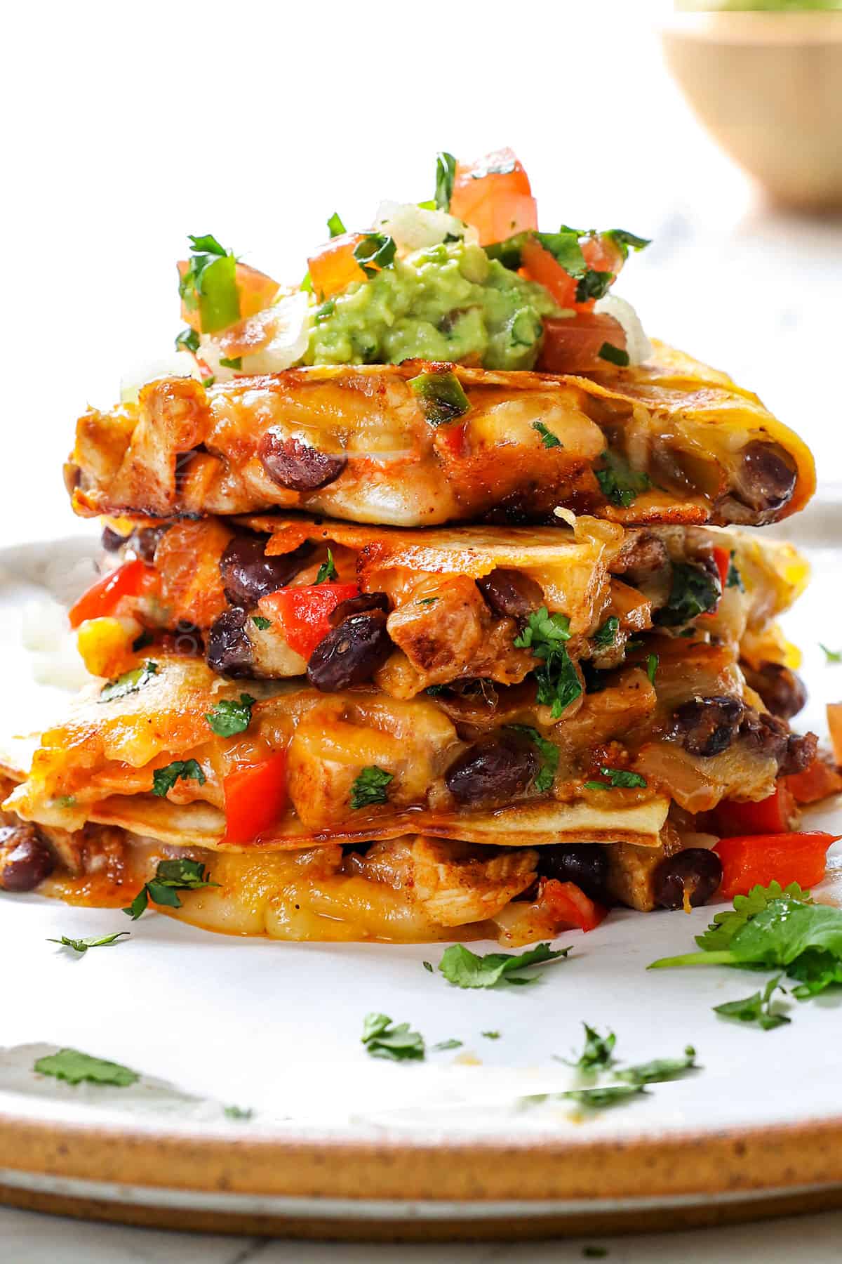 a stack of chicken quesadillas with chopped chicken, black beans, cheese and bell peppers 