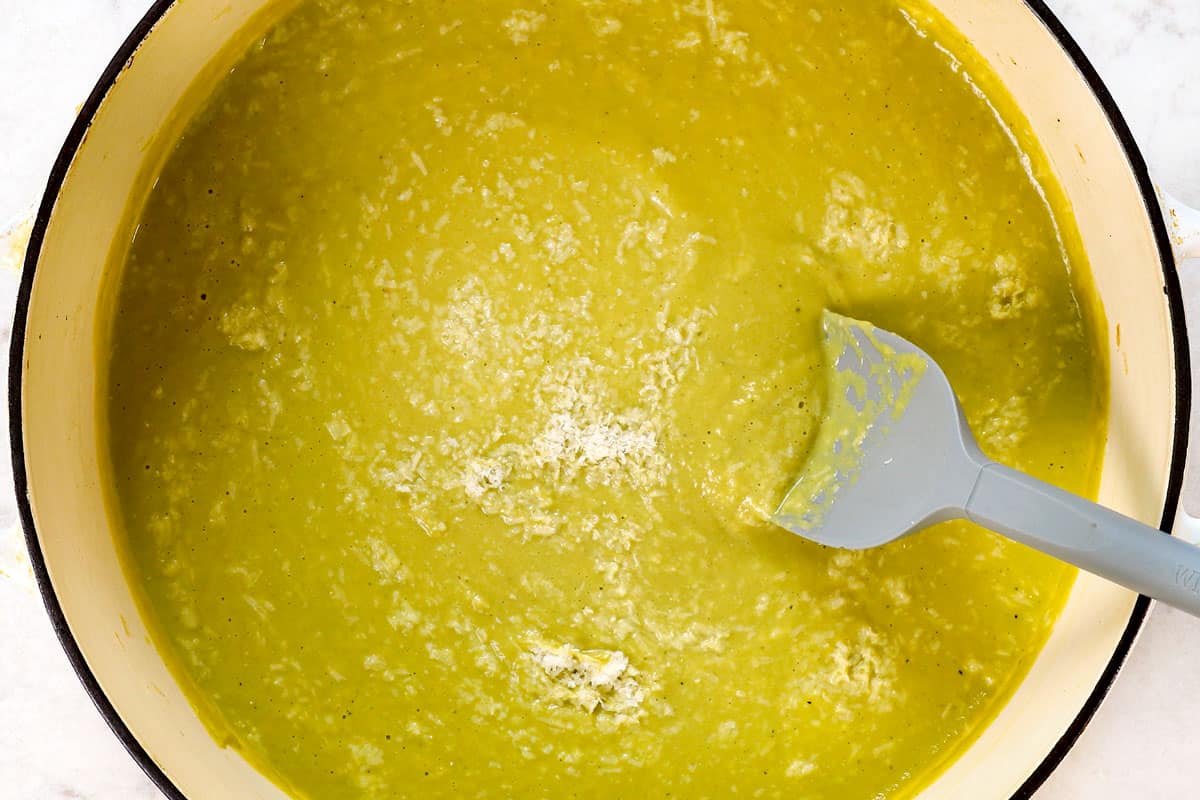showing how to make Cream of Asparagus Soup recipe by stirring in freshly grated Parmesan, basil and dill