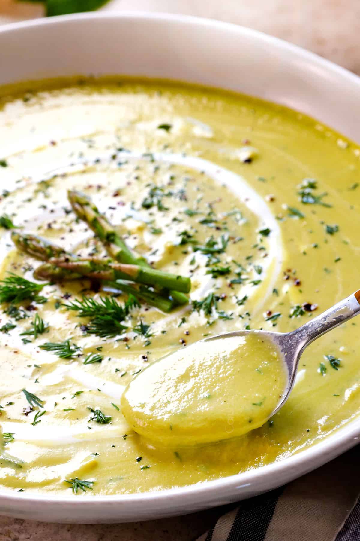up close of a spoon of cream of asparagus soup showing how creamy it is