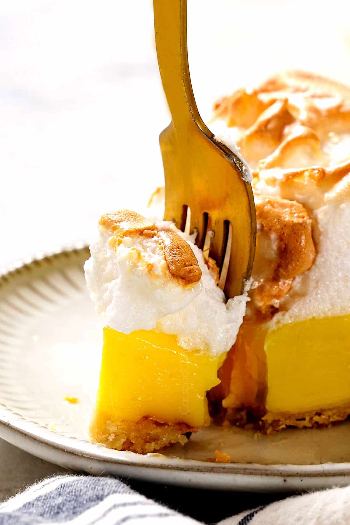 up close of a fork taking a bite of best Lemon Meringue Pie recipe showing how creamy the filling is 