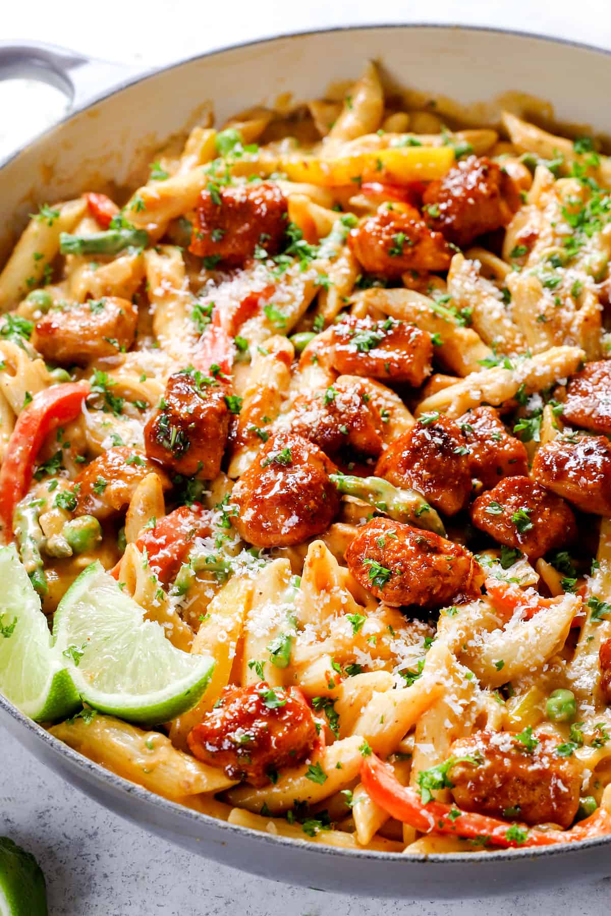 showing how to make spicy chicken chipotle pasta by combining chipotle chicken, asparagus, peas, bell peppers, and pasta in a chipotle cheesy sauce