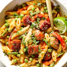a bowl of spicy chicken chipotle pasta showing hot to serve with parsley and limes