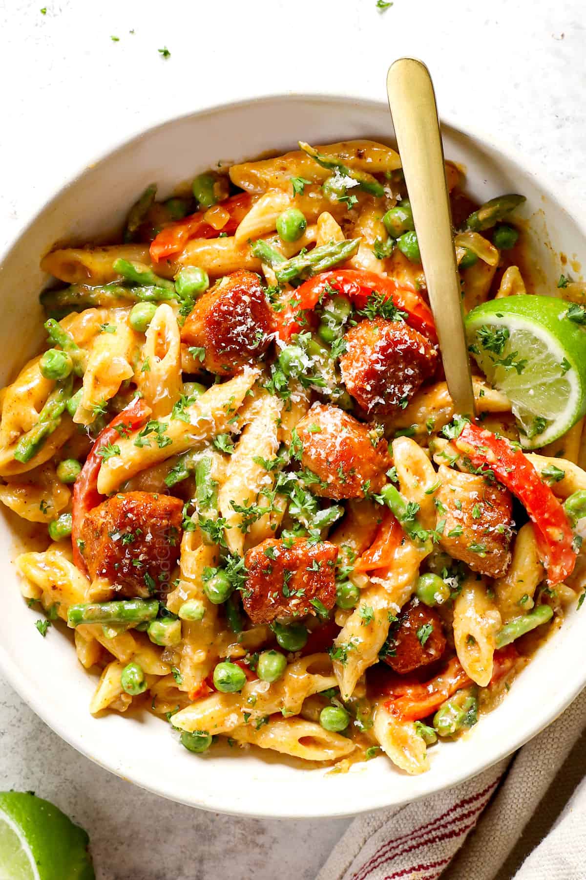 a bowl of spicy chicken chipotle pasta showing hot to serve with parsley and limes