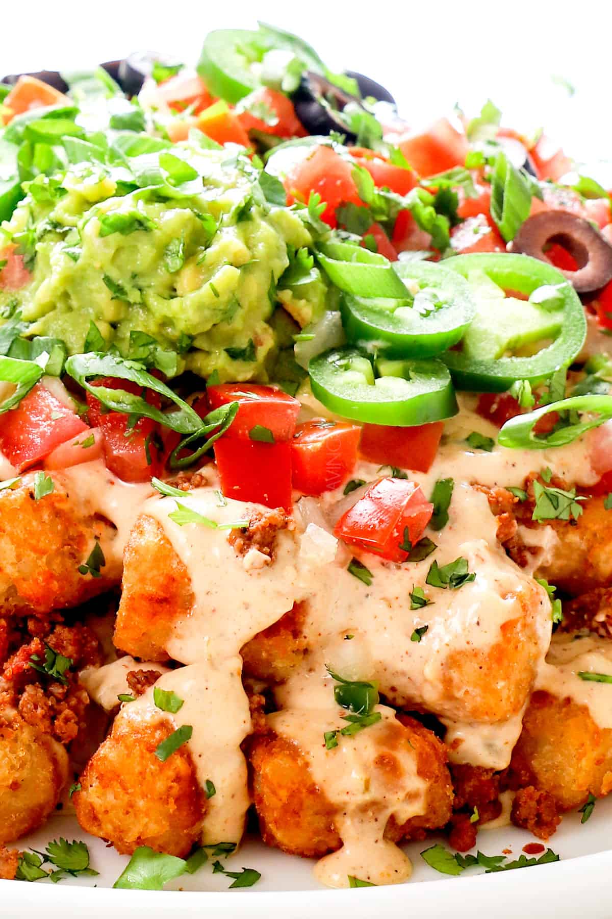 up closer of totchos (tater tot nachos) by adding cheese sauce to the tater tots