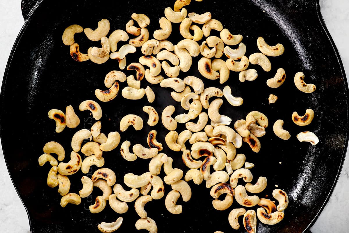 showing how to make spicy Dragon Chicken by toasting the cashews in a skillet
