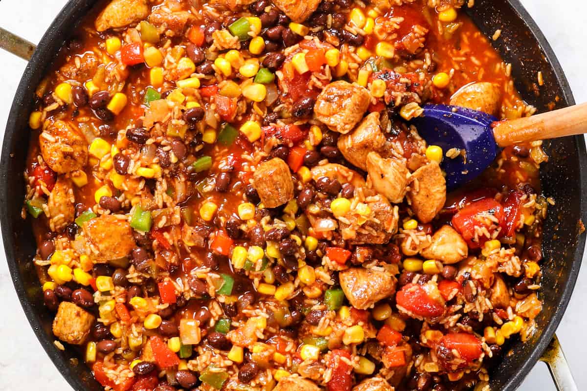 Showing how to make chicken fiesta and rice by simmering until the liquid is absorbed and the rice is tender