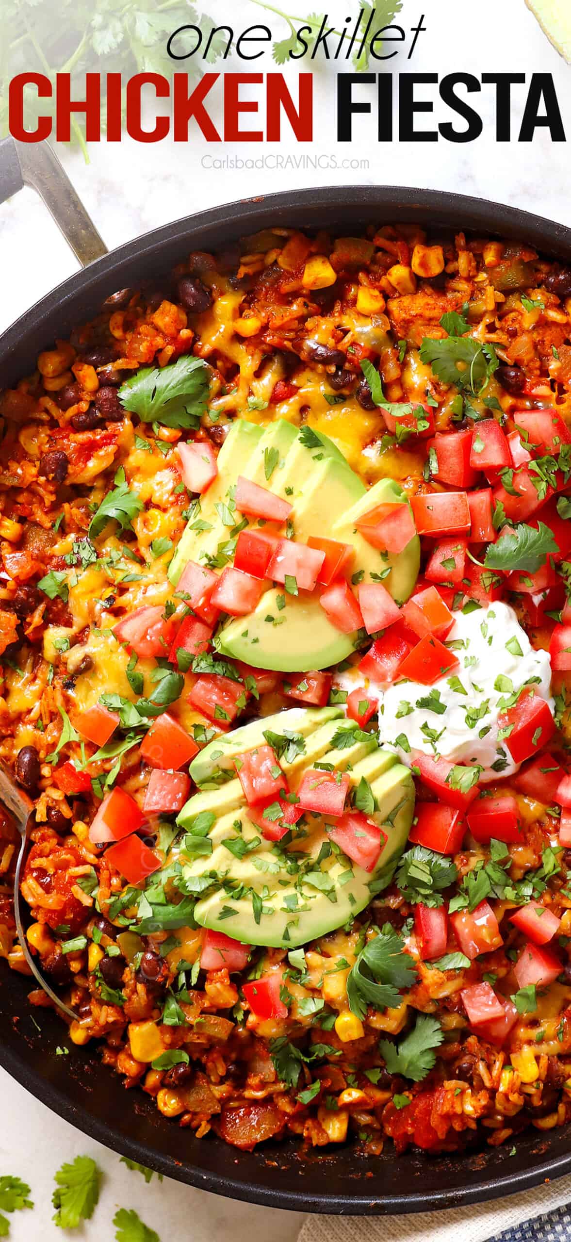 top view of Chicken Fiesta in a skillet topped with avocados and tomatoes 