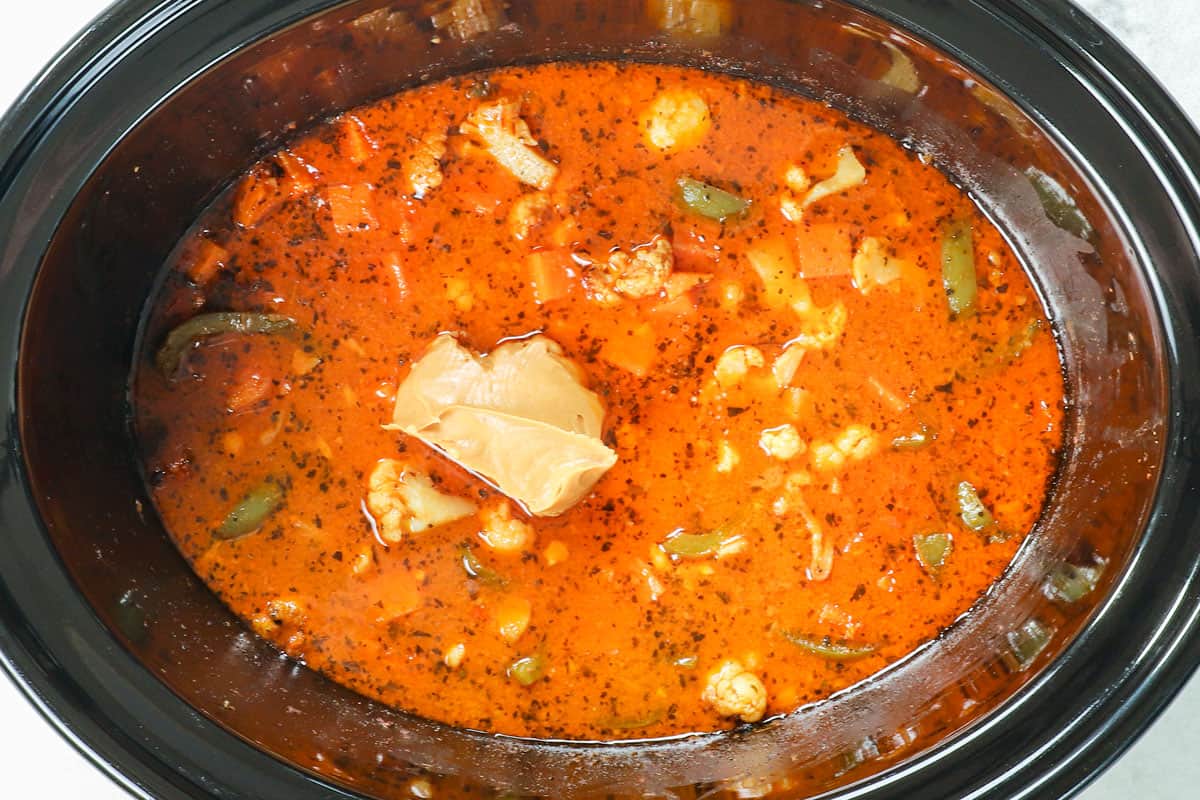 showing how to make Thai Crockpot Curried Chicken by stirring peanut butter into the slow cooker