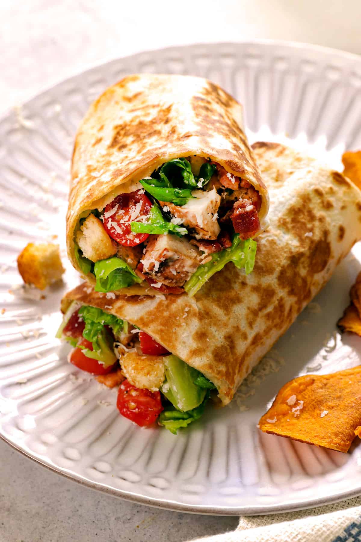 showing how to serve chicken Caesar wrap recipe by adding to a plate with chips