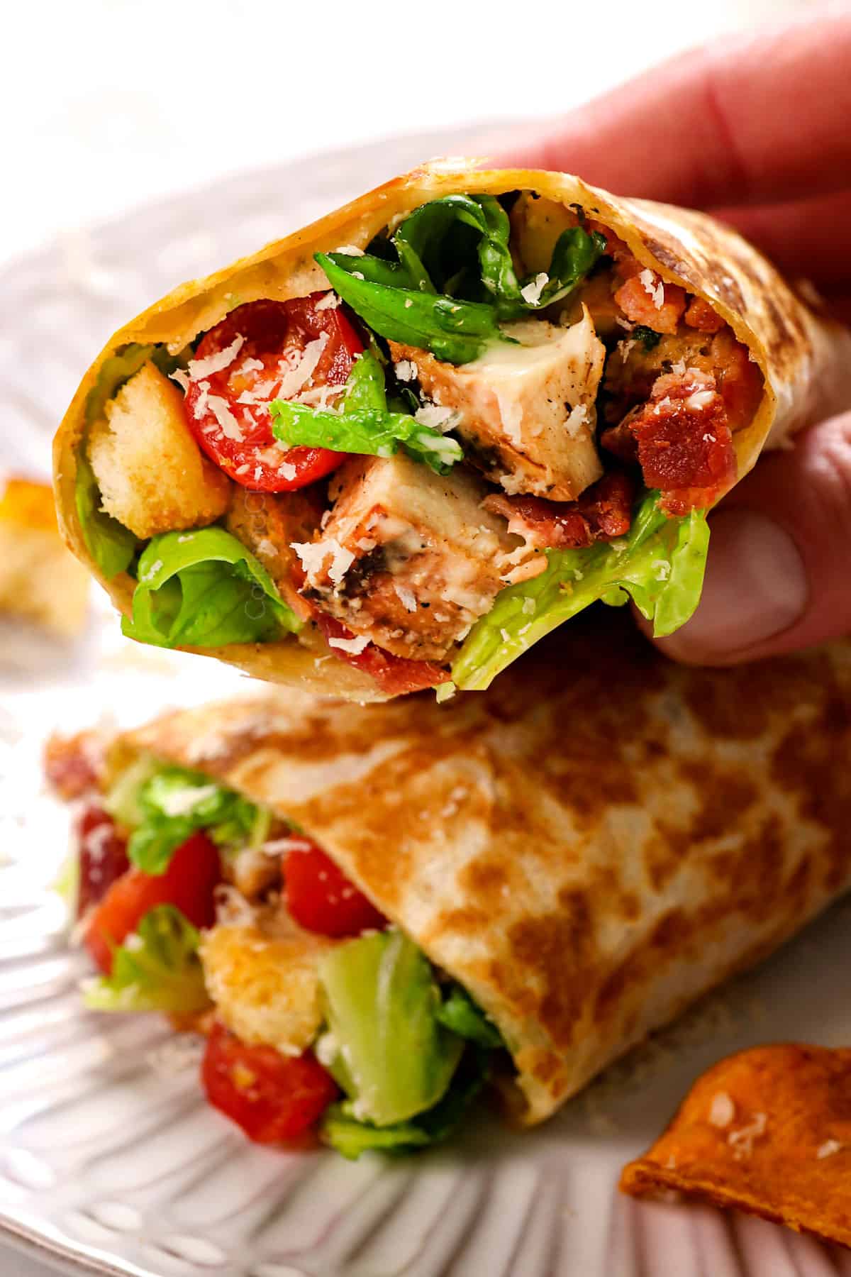 showing how to eat Chicken Caesar Wrap recipe by slicing in half and picking up 