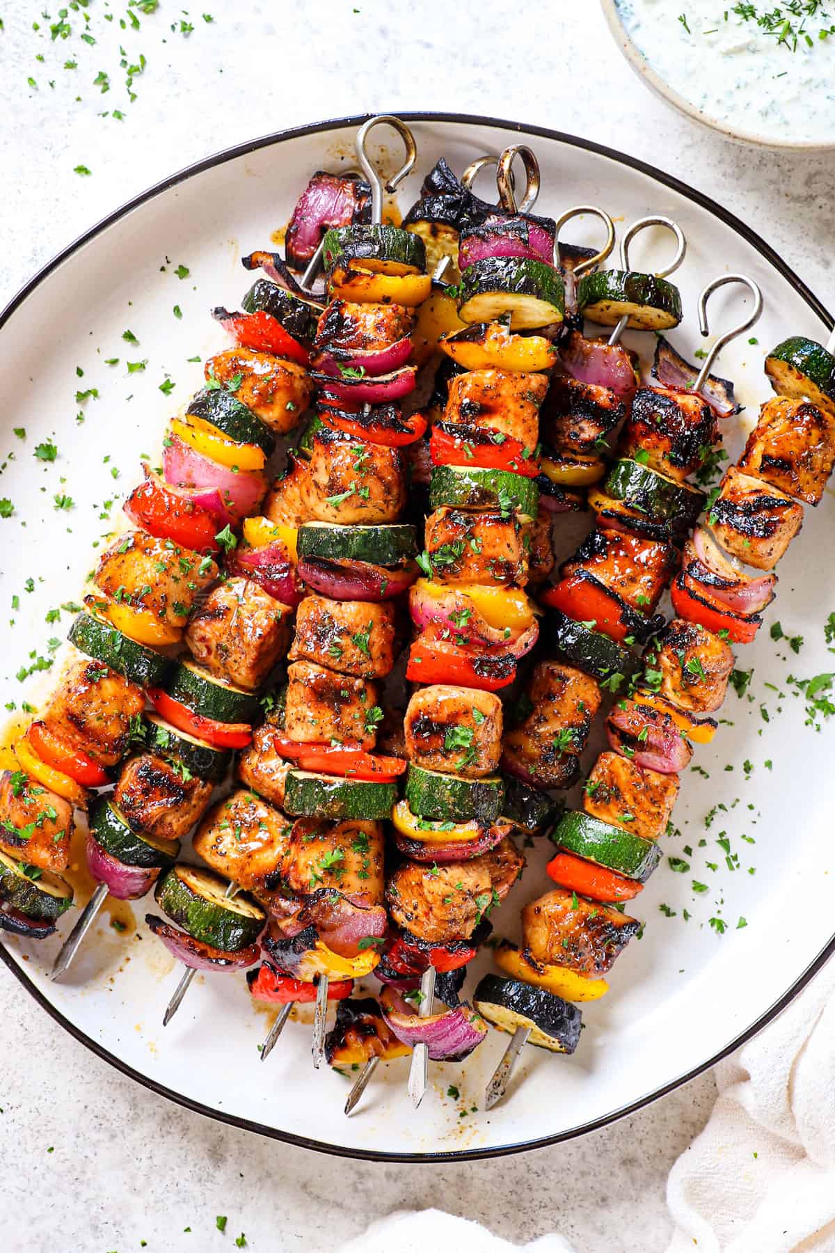 showing how to serve oven chicken kabobs (chicken kebabs) on a platter garnished with parsley