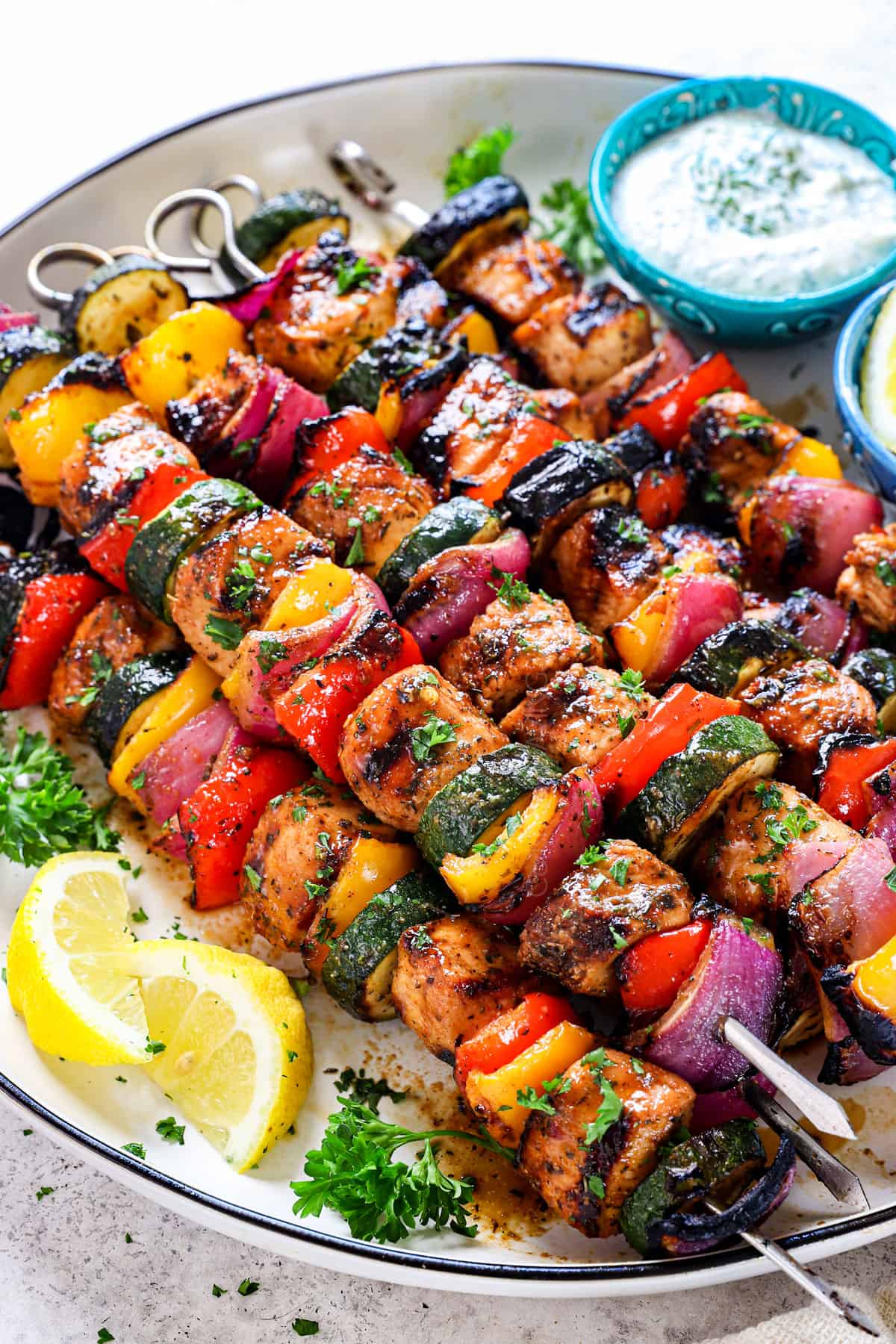 chicken kabobs (chicken kebabs) on a plate served with herb yogurt dip