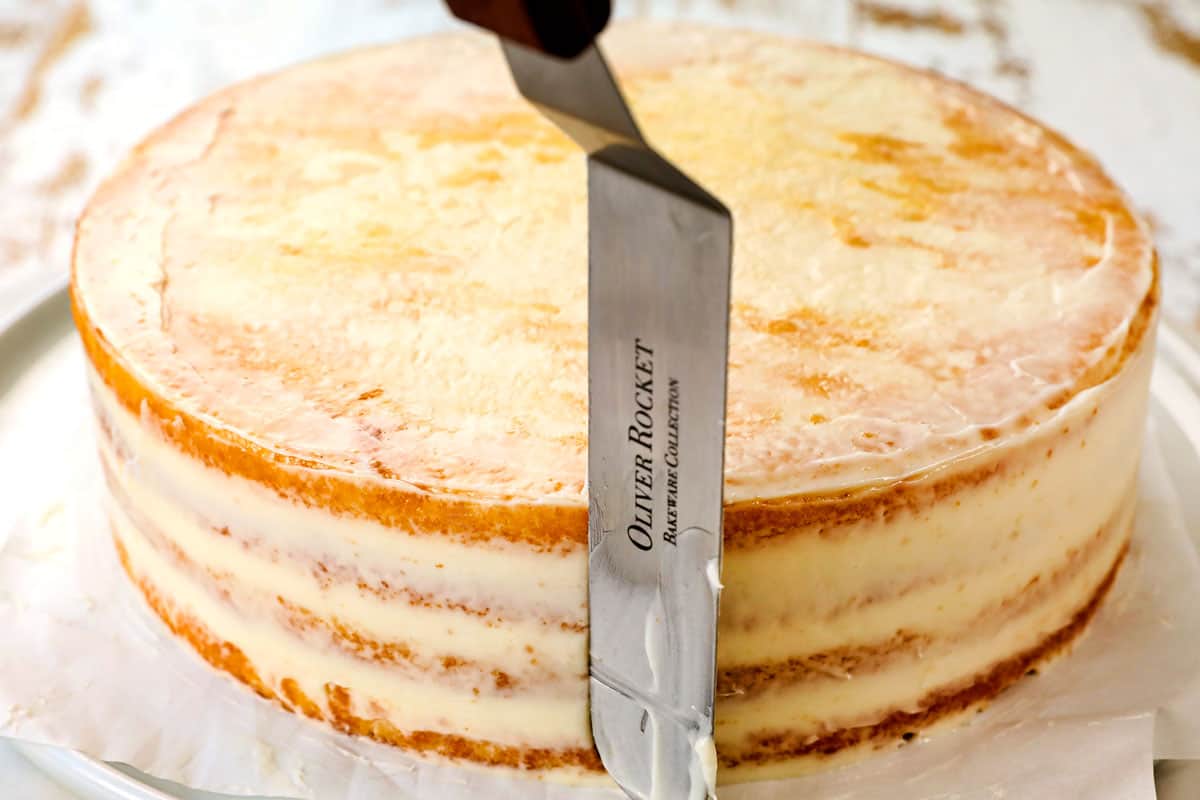 showing how to make lemon raspberry cake by adding a crumb coat to the cake
